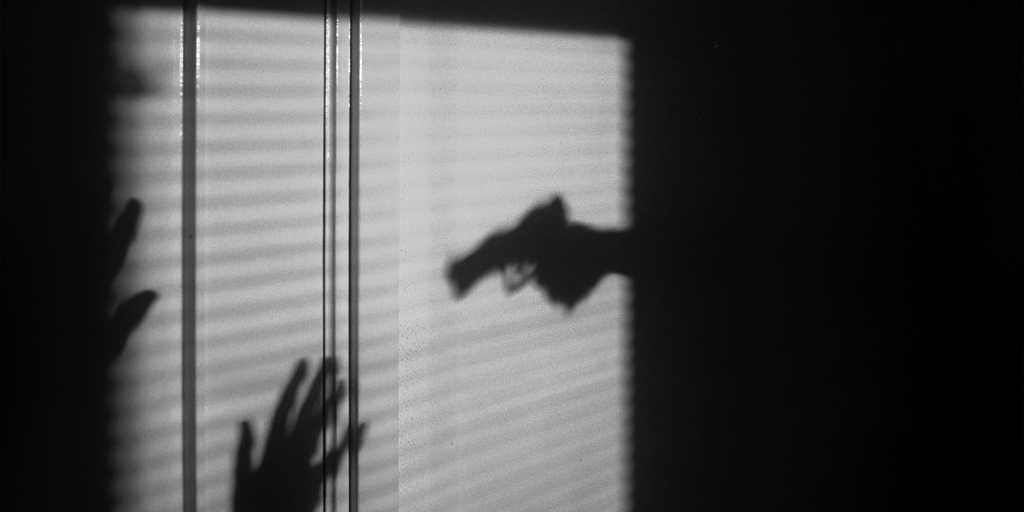 Shadow of a hand holding a gun